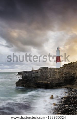 Portland Bill Lighthouse stands sentinel on the rugged south England coast as the suns last rays illuminate the impressive structure.