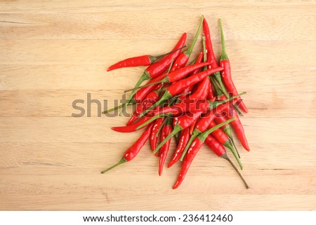 Pile of red chillies on wooden surface