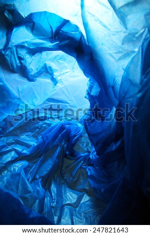 Abstract background of the insides of a blue plastic bag with different color shades