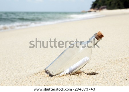 Message in a bottle on sandy white beach