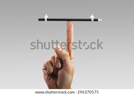Pencil balanced on finger with two paper figures on each end depicting balanced relationship