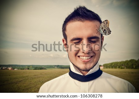 Face of a young man with a butterfly on forehead