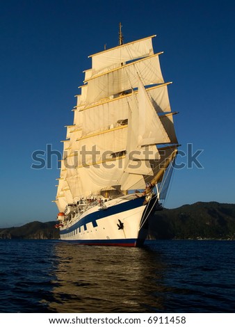Tall ship under full sails in the light of evening sun