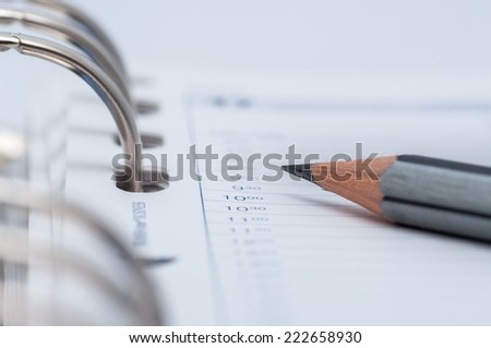 gray pencil on open business agenda, shallow DOF