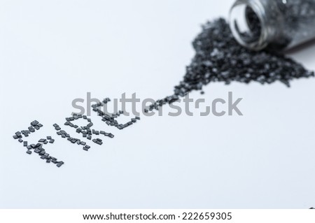 Black gunpowder on white background with word fire written from gun powder and a match stick shallow DOF