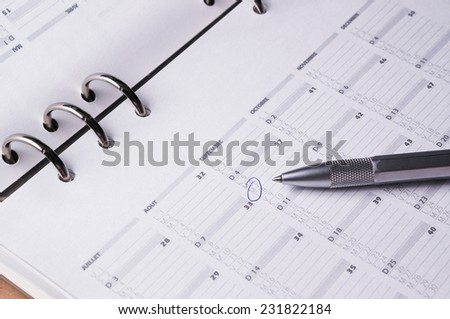 silver pen on open business calendar