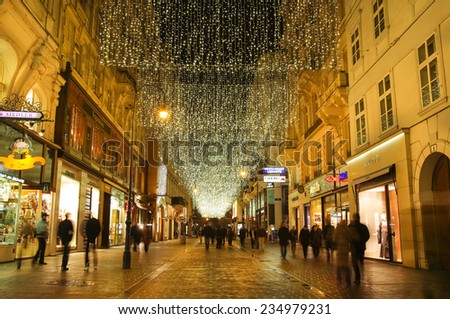 VIENNA, AUSTRIA - December 11, 2009: Vienna -  street at night with tourists and Christmas chandeliers in Vienna, Austria. on December 11, 2009