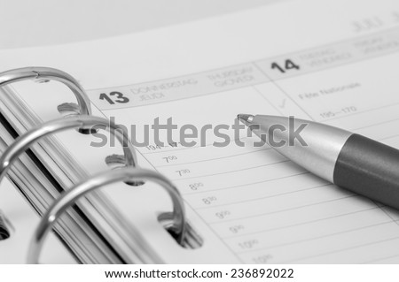 silver pen on open business agenda in black and white