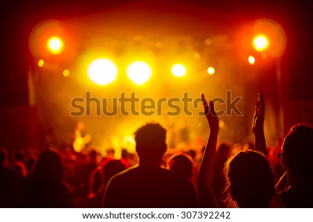 crowd at a concert in a red light, noise added