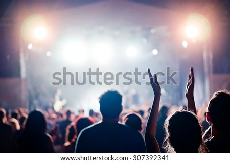 crowd at a concert in a vintage purple light noise added
