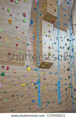 Grungy surface of an artificial rock climbing wall with toe and hand hold studs.