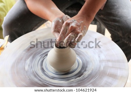 Traditional pottery sculpting in Saigon, Vietnam. Horizontal shot of just hands sculpting a small vase out of clay.