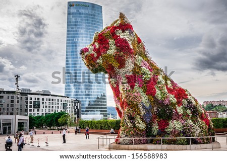 BILBAO SPAIN OCTOBER 1 Iberdrola Tower and Puppy sculpture on October 1 2013 in Bilbao Spain The tower was designed by architect Caesar Pelli and the Puppy sculpture by Jeff Koons BILBAO SPAIN OCTOBER 1 Iberdrola Tower and Puppy sculpture on October 1 2013 in Bilbao Spain The tower was designed by architect Caesar Pelli and the Puppy sculpture by Jeff Koons