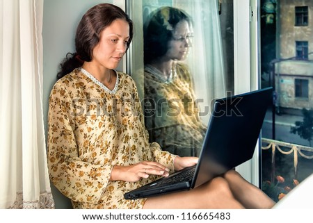 The young woman at the window with a laptop