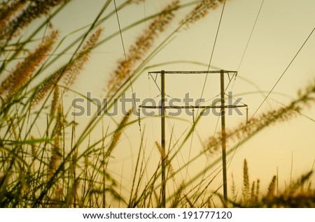 Energy Distribution Network - Electricity Pylons against Orange and Yellow Sunrise