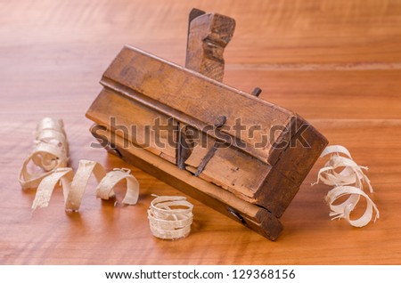 old molding plane with shavings on a cherry wood board