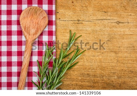 Rustic wooden background with checkered tablecloth and wooden spoon