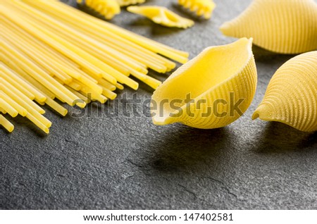 Different types of pasta on a slate background