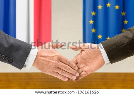 Representatives of France and the EU shake hands