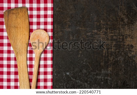 Old baking tray with red checkered tablecloth and cooking utensils