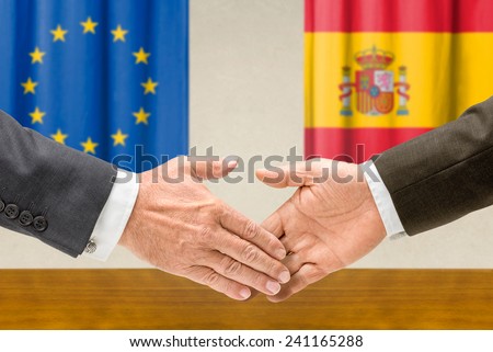 Representatives of the EU and Spain shake hands