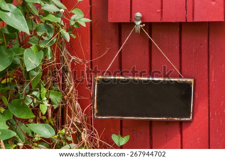 Empty metal sign in front of a red wooden wall