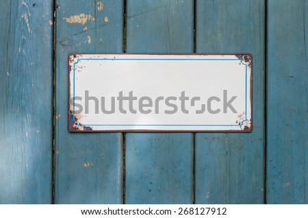 Empty metal sign in front of a wooden wall