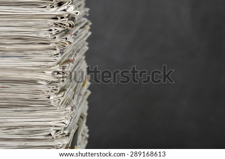 A pile of newspapers in front of a blackboard