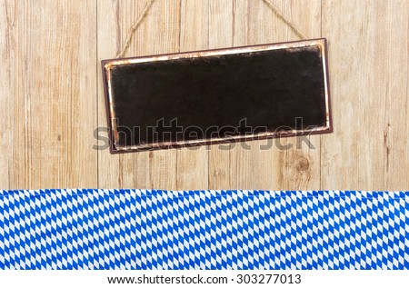 Empty metal sign on a wooden wall with Bavarian decor