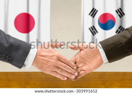 Representatives of Japan and South Korea shake hands