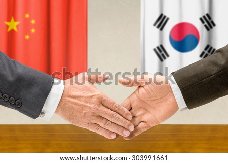 Representatives of China and South Korea shake hands