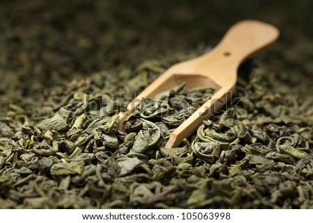 Green tea leaves full frame and wooden scoop