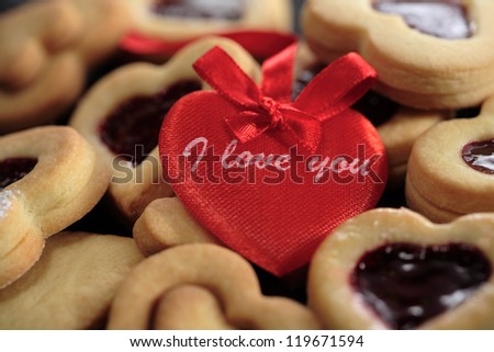 Heart-shaped cookies with black currant jam and sign \