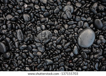 Black pebble as a background.  Black sand beach as a background. Hawaii, Maui, USA