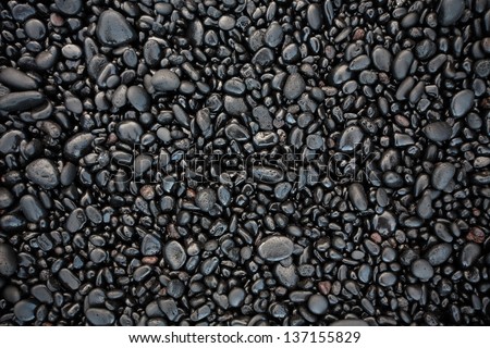 Black  stones on a Black sand beach as a background. Hawaii, Maui, USA