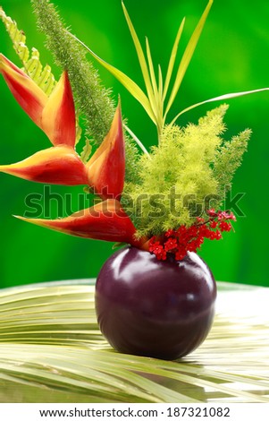 Heliconia and Bird of Paradise flowers in a vase in the garden. Hawaii, Maui, USA
