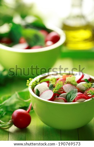 Mixed green salad with  radish and Rocket leaves in green bowl