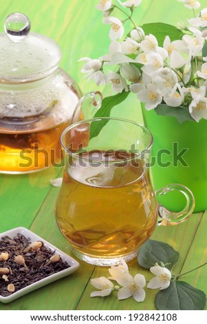 Jasmine tea cup and tea pot, jasmine flowers in a vase