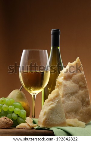 White wine bottle,  white wine glass, white wine grapes and parmegiano cheese still life