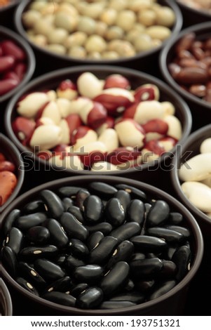 Assortment beans in round bowls as a background