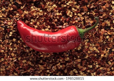 Red chili pepper on ground chili pepper background