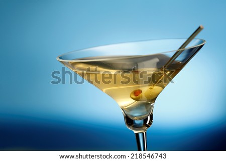 Martini glass with olive, sea on the background