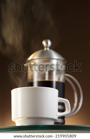 White Espresso cup with  steaming coffee and a French Press/Cafetiere