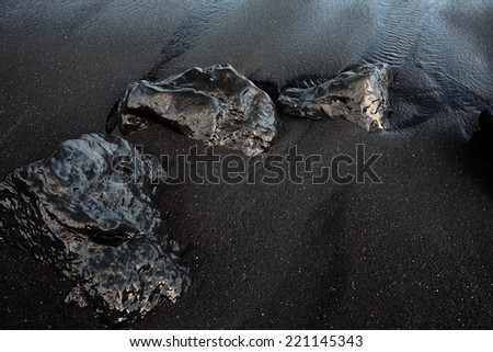 Black rocks on a Black sand beach. Hawaii, Maui, USA