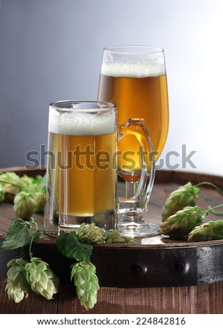 Hops and beer glass on beer barrel still life