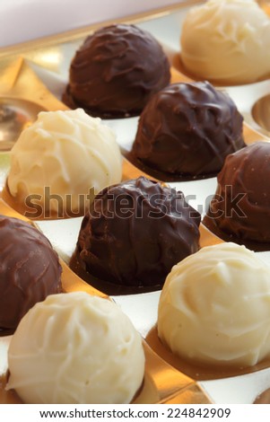 Closeup of  ball-shaped chocolates made with black chocolate, white chocolate and milk chocolate