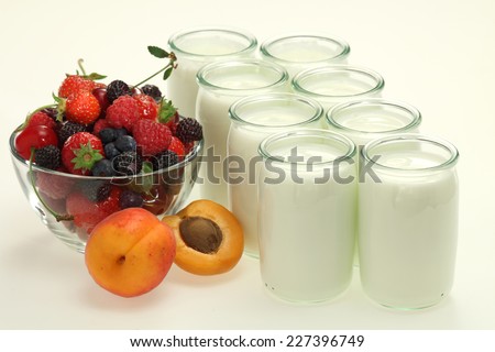 Many yogurt jars of fresh live homemade yogurt with fresh fruits and berries