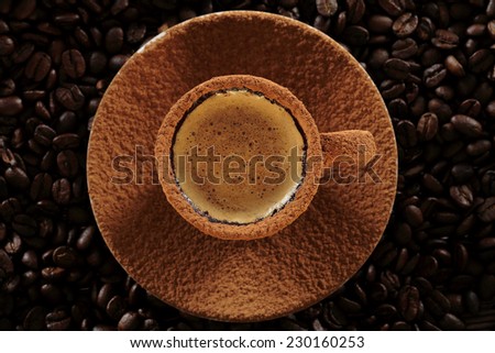 Cup of coffee covered with cocoa powder on coffee beans background