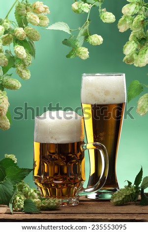 Beer glass and hops on beer barrel still life
