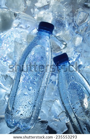 Mineral water bottles on ice cubes background